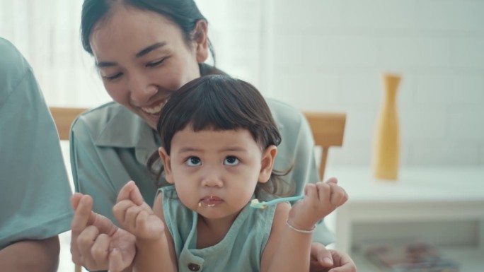 幸福的一家人，儿子和女儿在家里玩五颜六色的塑料积木