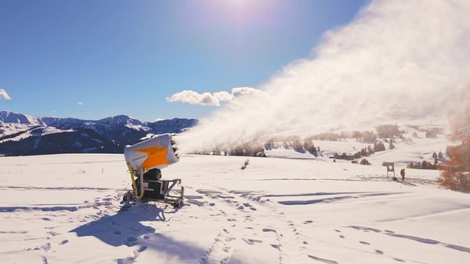 空中无人机拍摄的雪炮机吹雪在Alpe Di Siusi白云石蓝天下的晴天