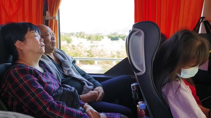 旅游在客车上休息大巴士困了睡觉的乘客游人
