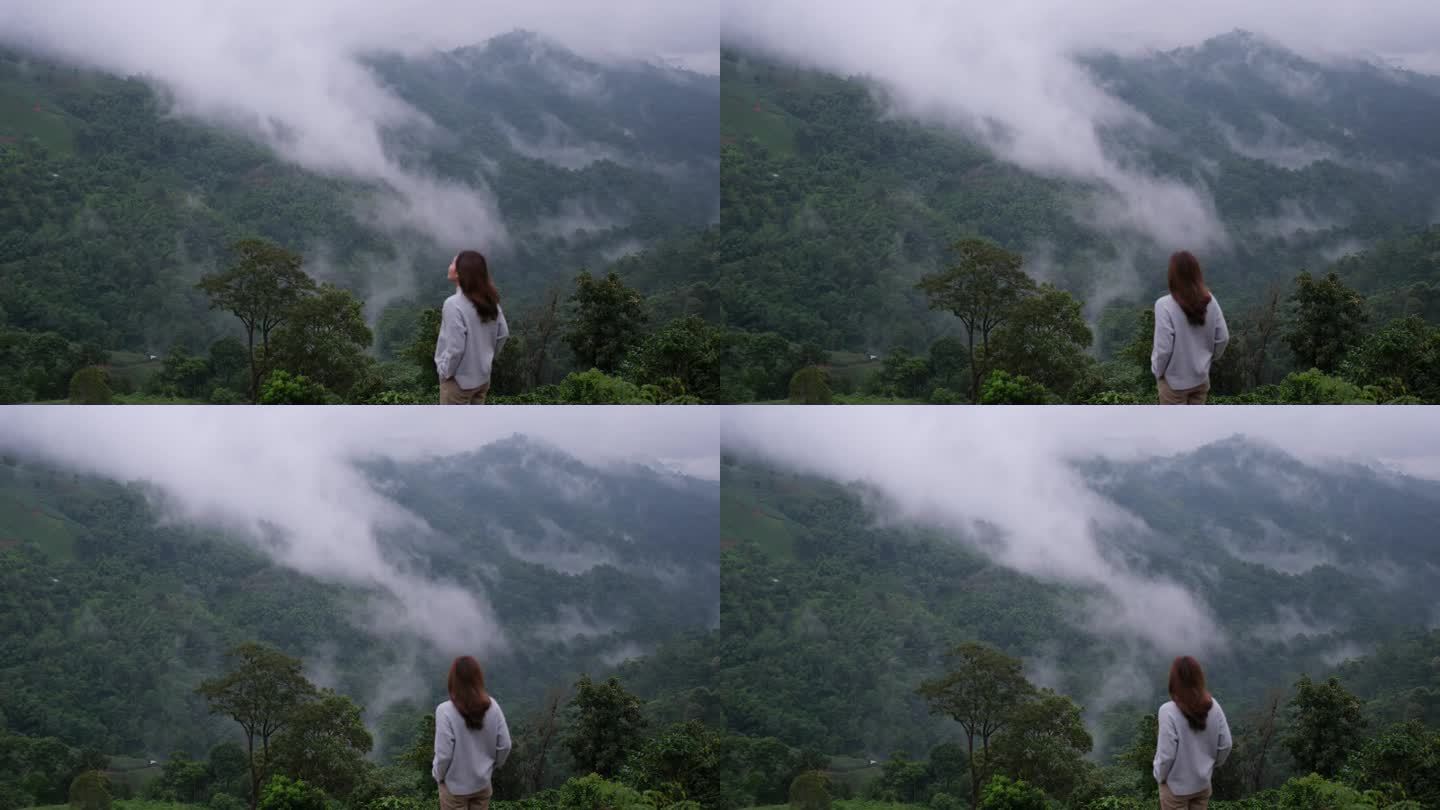 一个女人在雾天看美丽的山景