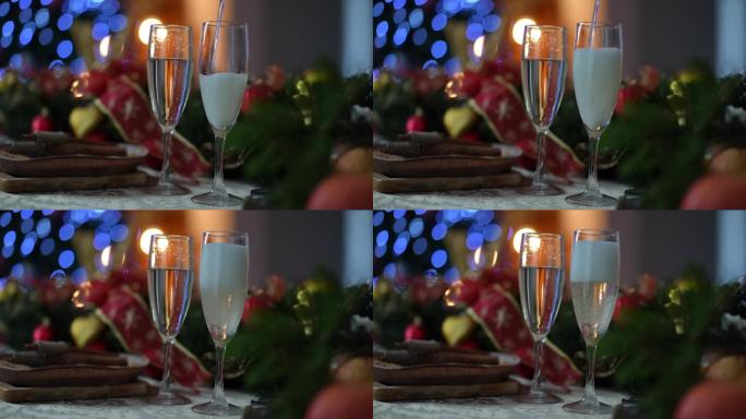 在喜庆的圣诞餐桌上，白起泡酒被倒进香槟杯中。圣诞节和新年庆祝概念。