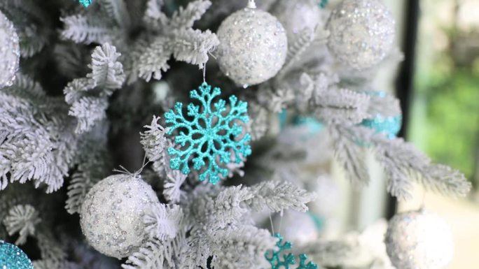 装饰物装点的圣诞树特写，圣诞球、灯饰和雪花