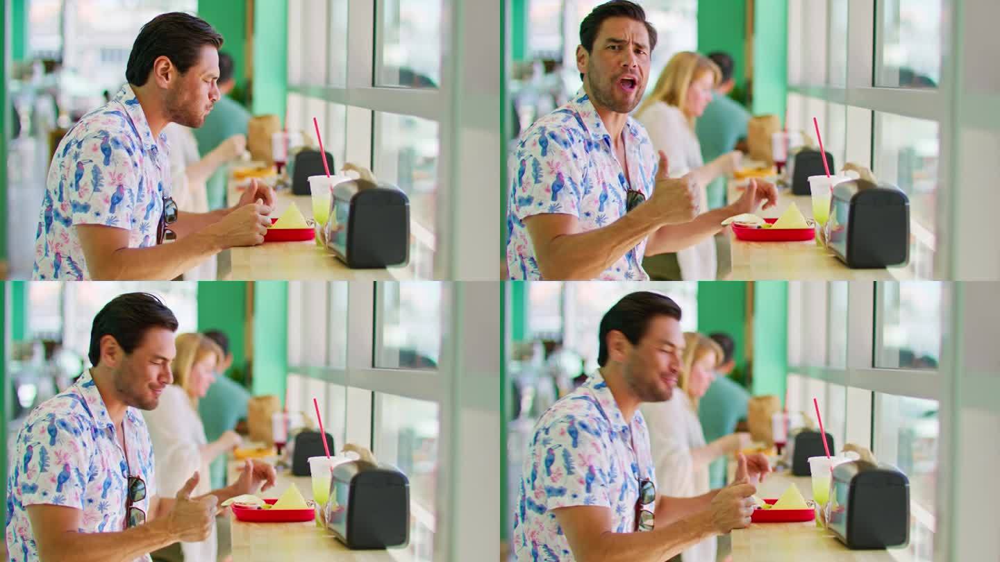 一名男子在吃墨西哥食物时对着镜头竖起大拇指