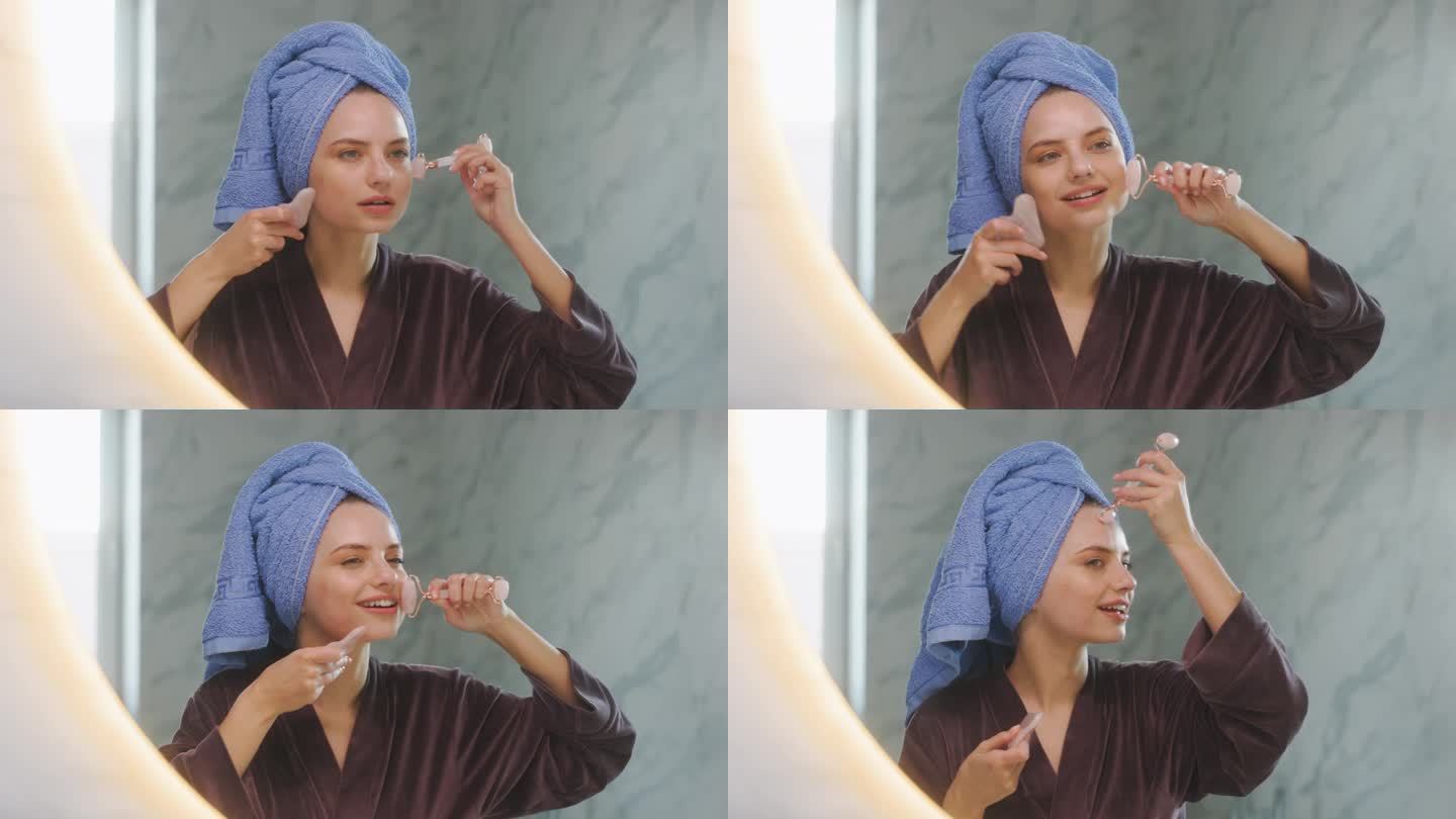 这个女人穿着睡袍，头上缠着毛巾，站在家里浴室的镜子旁边。女孩洗完澡后正在给自己做面部按摩。