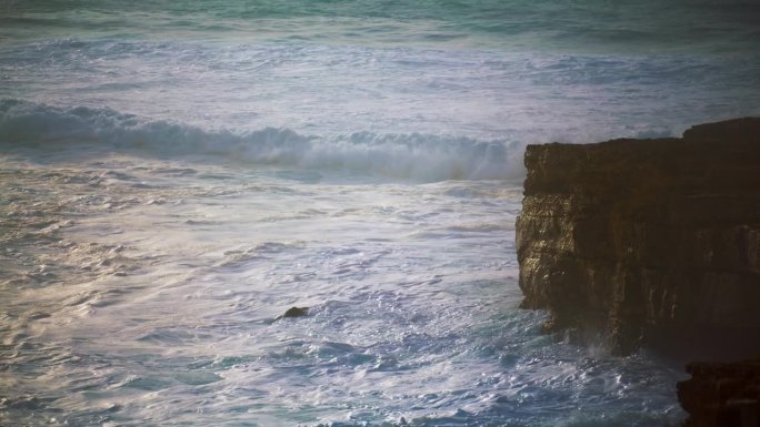 汹涌的海浪翻滚着悬崖海岸。泡沫飞溅的海洋冲刷着岩石海岸