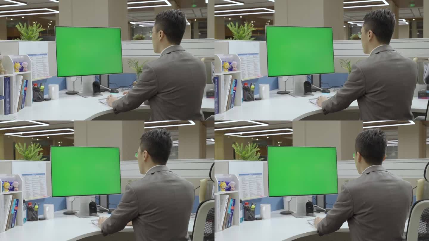人物在绿幕电脑前办公