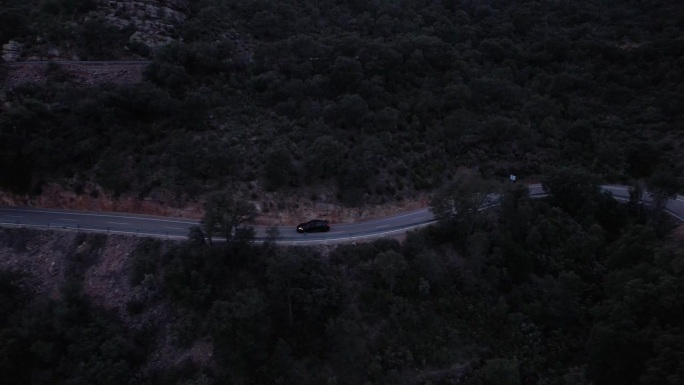 黎明时分，汽车行驶在偏僻的山脊上，电影中的航拍镜头拍摄了本田思域r型
黄昏时偏僻的山口