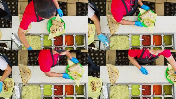 高角度拍摄的餐厅工作人员添加浇头的菜肴在墨西哥餐厅