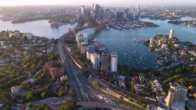 在一个阳光明媚的清晨，航拍无人机从悉尼市区、悉尼港和海港大桥向新南威尔士州拉文德湾反向拍摄