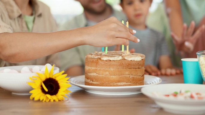 生日蛋糕、蜡烛和幸福的家人一起在家里用掌声、歌声和糖果庆祝。快乐，兴奋的庆祝和祝贺，人们在孩子们的聚