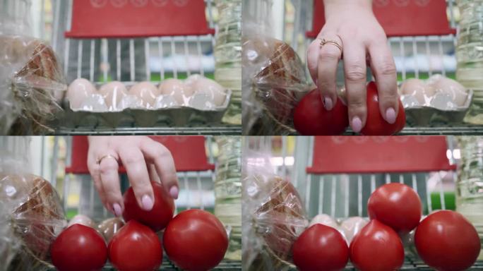 一名妇女推着手推车穿过超市，在商店里购买食品杂货，把西红柿放在蔬菜部的手推车里。