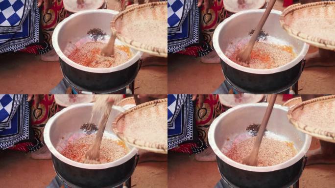 传统的非洲烹饪场景，手往锅里倒芝麻。