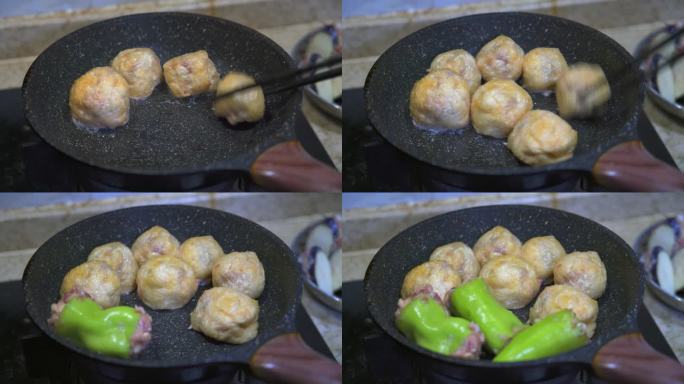 一位厨师在用平底锅煎制酿菜，酿辣椒酿油果