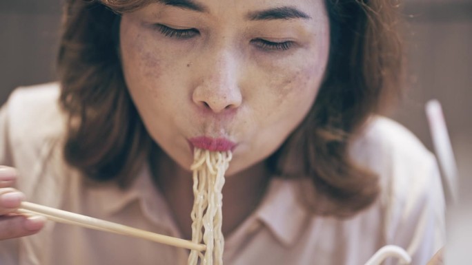 女人在吃拉面、日本汤面。
