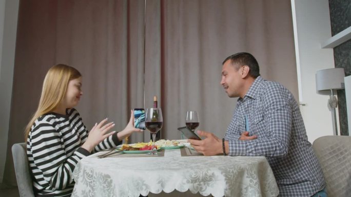 一对听力受损的快乐放松的夫妇在晚餐时讨论网络内容