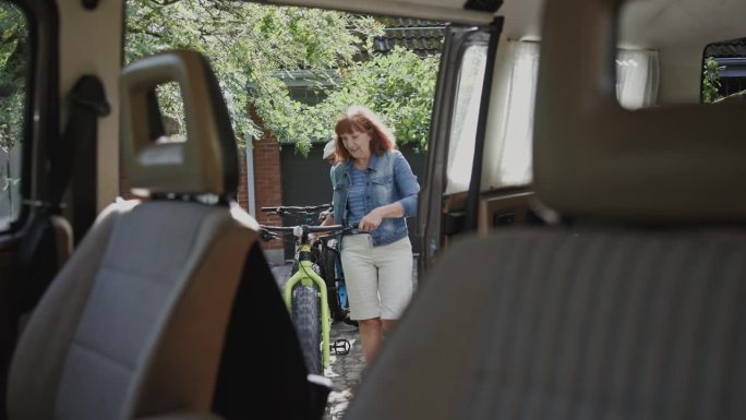 一对老年夫妇把自行车装进他们的露营车。