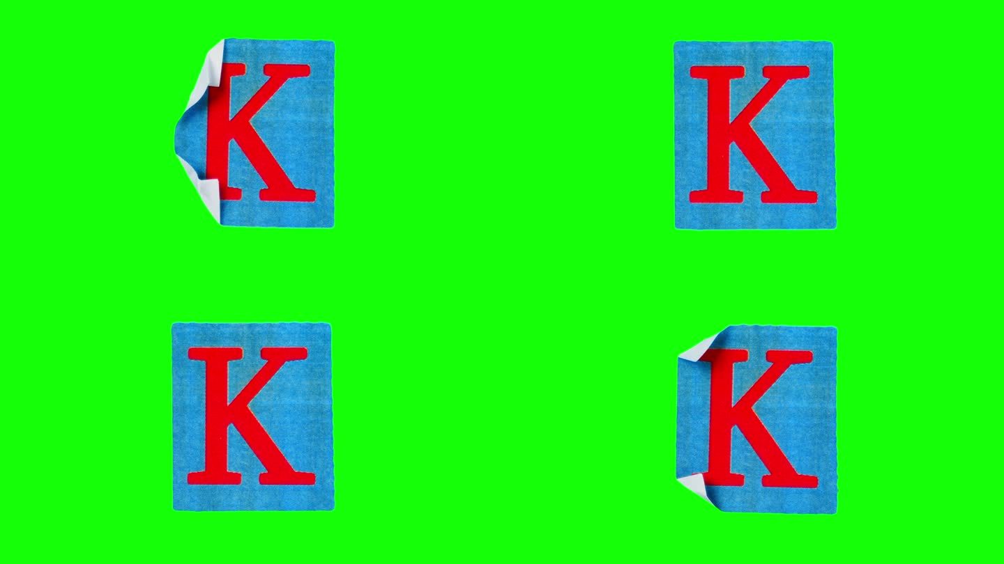 首字母K在皱巴巴的蓝色页面上以定格动作拍摄，背景是绿色的屏幕