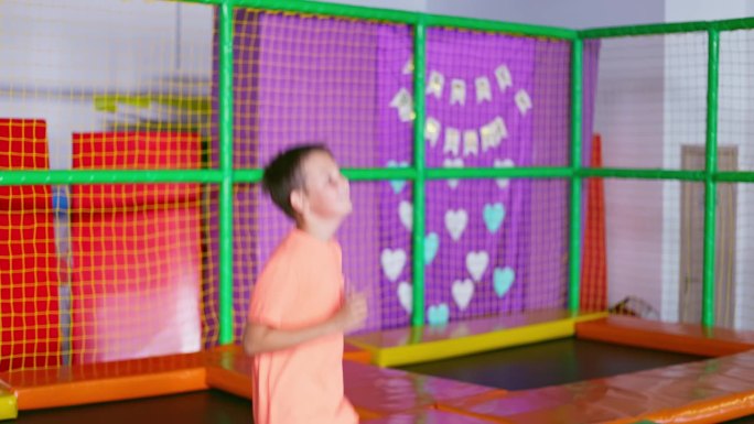 一个孩子在游乐场的蹦床上蹦蹦跳跳。操场上活跃的儿童游戏