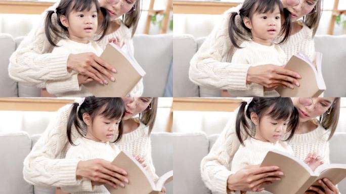 亚洲漂亮的孕妇妈妈在闲暇时间和大女儿一起在客厅看书，妈妈教宝宝读书，给小孩子讲故事。家庭幸福观