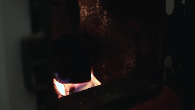 锅炉里明亮的火焰为房子供暖。用固体燃料锅炉代替电力和燃气。