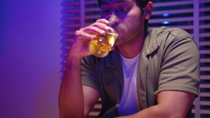 一个年轻人坐在咖啡馆里喝啤酒，直到喝得酩酊大醉。