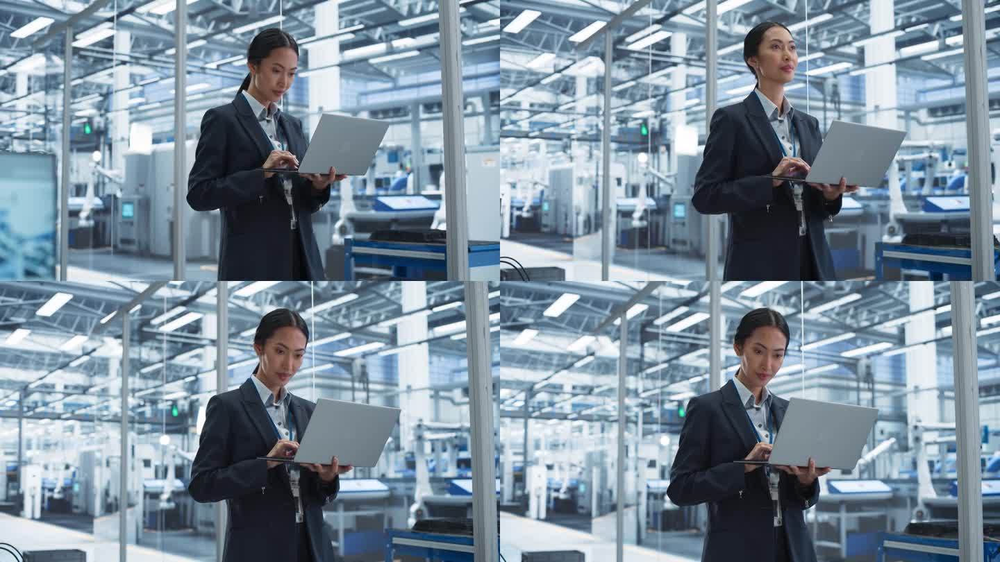 亚洲工厂经理在未来工业制造的笔记本电脑上工作，自动机器人装配线。专人监督生产，为员工计划工作