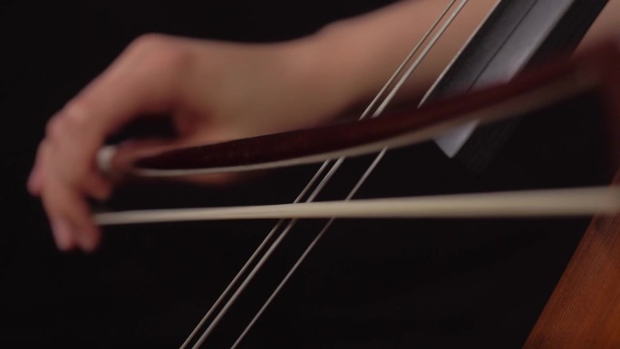 女人用弓演奏大提琴的特写