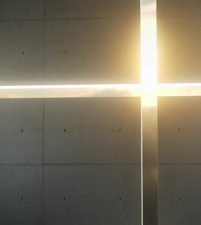 阳光透过墙上一个十字形的洞照进来。