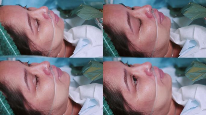 手术中麻醉下带呼吸管躺在手术台上的病人特写。手术室麻醉下的女病人画像。病人在掩护下。