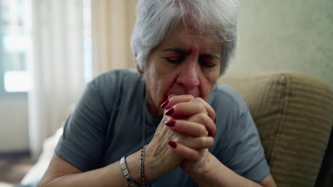 孤独的老年白人妇女，在家中进行充满希望的祈祷，一位虔诚的老人信仰的体现