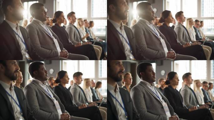 一名非洲男子坐在科技会议拥挤的礼堂里。专业商人聆听主题演讲。专家观看新软件解决方案的创新技术展示。