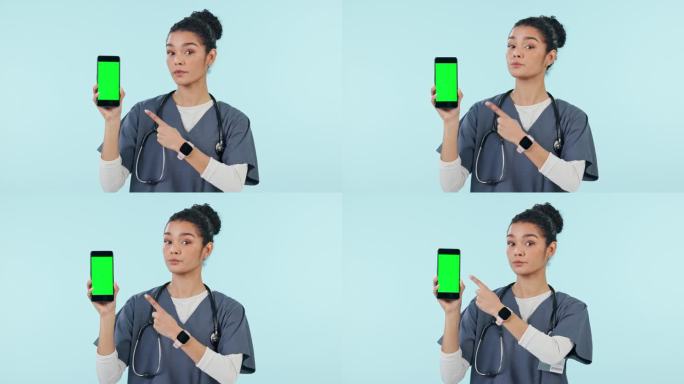 一个女人，护士和手机指着绿屏，在一个工作室背景的广告模型上。女性、护士或医生的肖像，展示手机应用程序