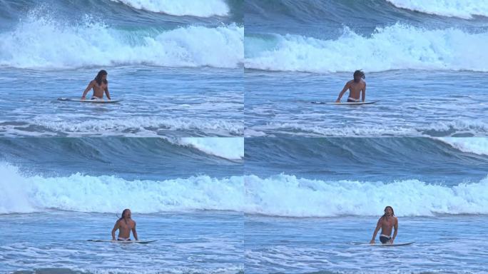 男子冲浪者与冲浪板在海上自然和海浪的背景。海岸边沙滩上的冲浪板不见了。海滨海湾的肖像男转向游泳或冲浪