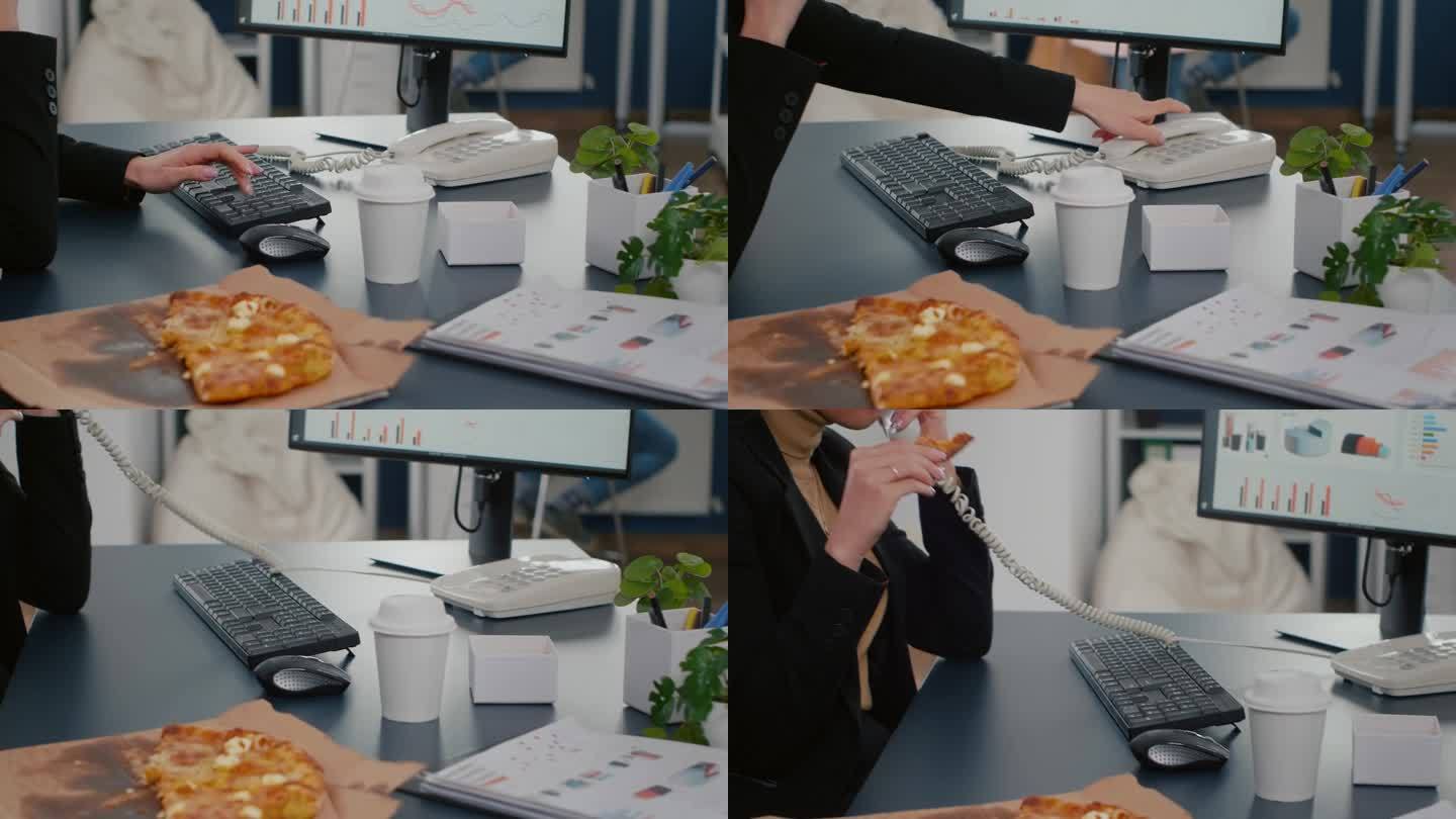 女商人坐在电脑前吃披萨片的特写