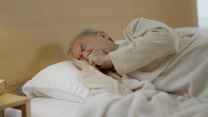老人睡觉时咳嗽，醒来后喝水。
