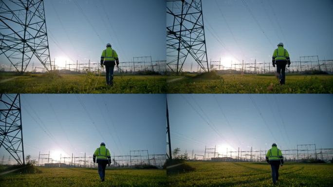 男性电气工程师在电站草地上行走的无人机镜头