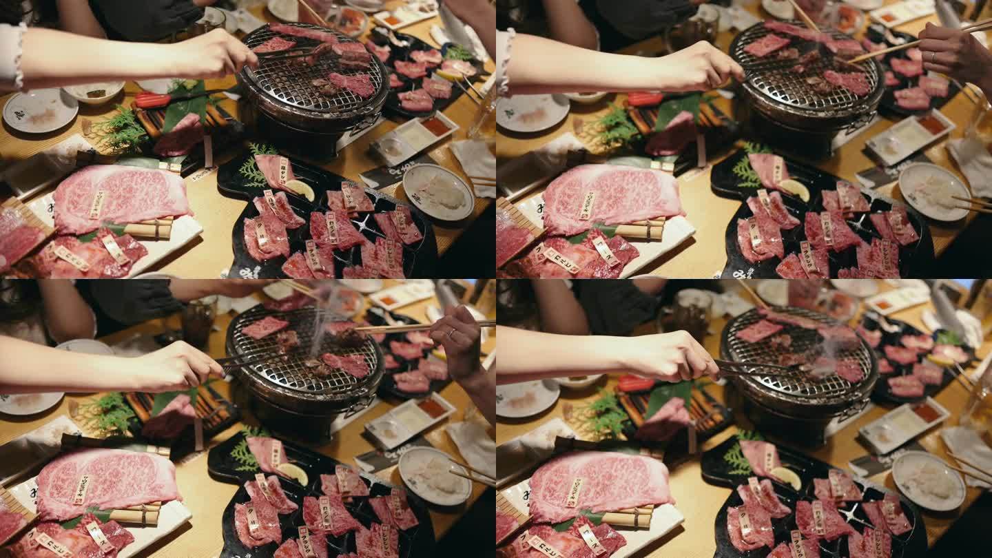 一名年轻的亚洲女子在一家餐馆里吃着传统的日式牛肉烧烤“Yakiniku”，并把生牛肉片放在木炭烤炉上