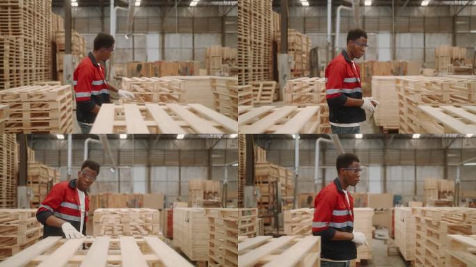 技术工人保证质量:非洲人在木棚检查库存托盘。