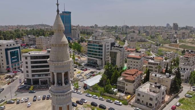 巴勒斯坦拉马拉市巴勒斯坦塔电影院、居民区和穆斯林清真寺尖塔。-空中回拉