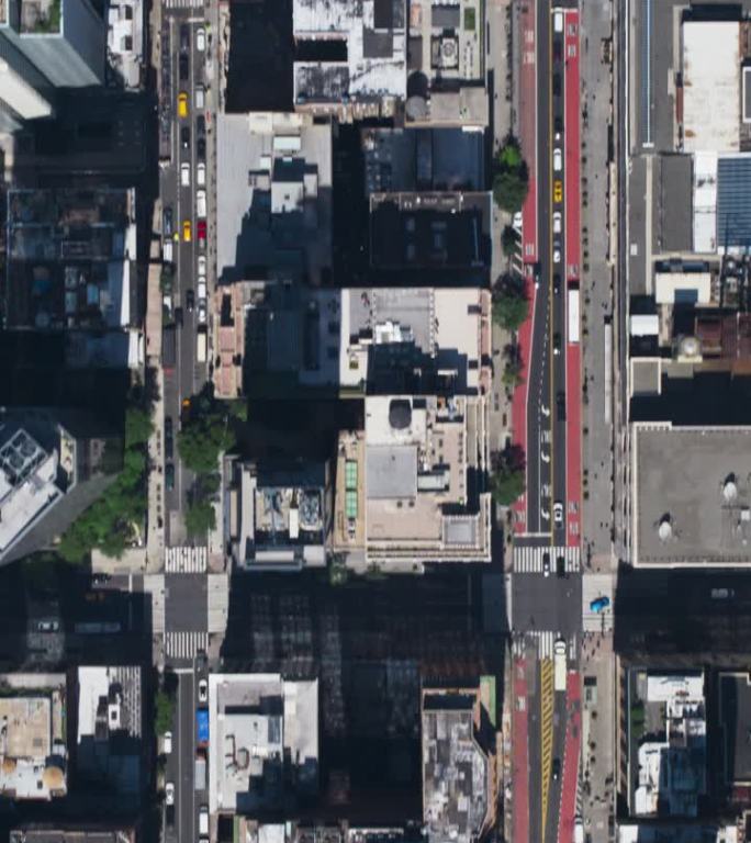 垂直屏幕:自上而下鸟瞰纽约市街道与可见网格系统，商业和住宅建筑屋顶。繁忙的都市交通，汽车，黄色出租车