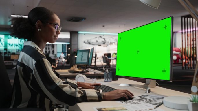 创意黑人女性使用桌面电脑与模拟绿屏Chromakey。在游戏设计初创公司工作的女性概念美术师，为新的