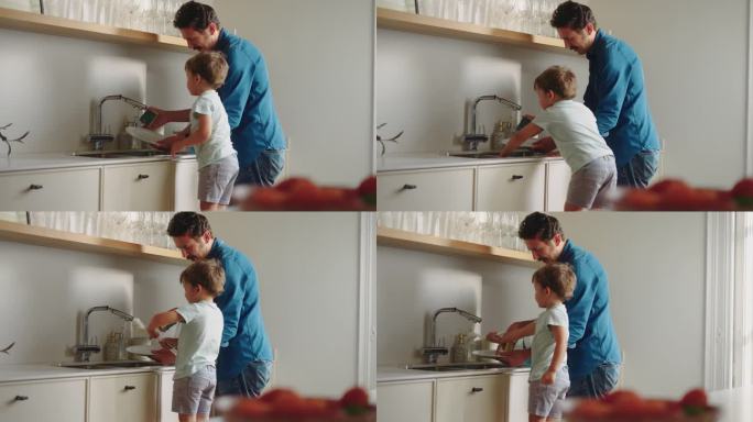 父亲正在厨房教儿子洗盘子