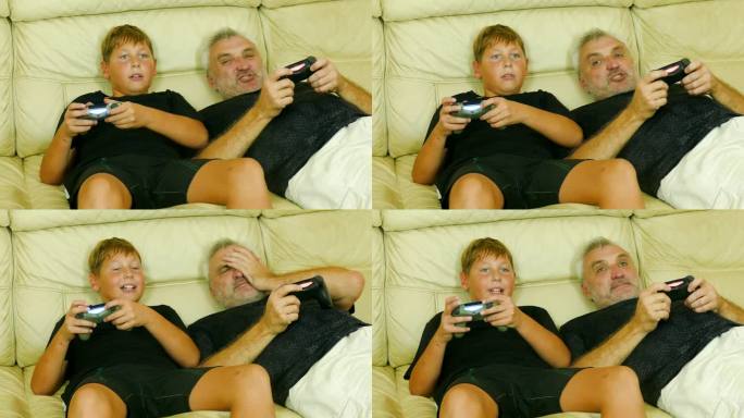 父子俩在家里的沙发上兴奋而不诚实地玩着电脑游戏