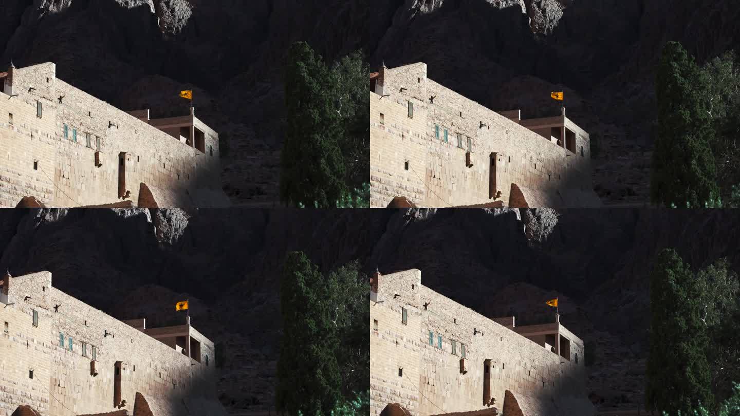 圣凯瑟琳修道院屋顶上的拜占庭帝国双头鹰旗。西奈山的古代历史宗教场所。游览摩西山