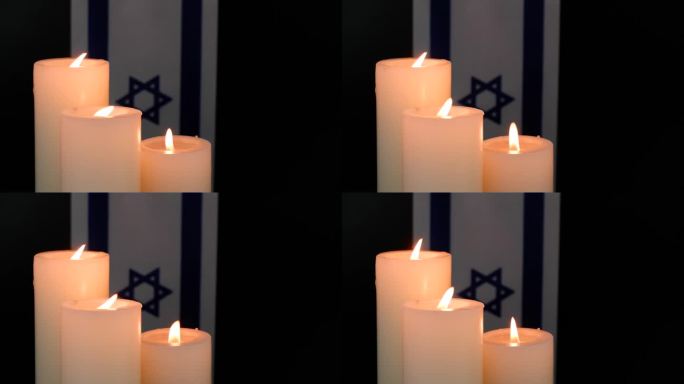 黑色背景上的以色列国旗和燃烧的蜡烛。纪念和祈祷的概念。
