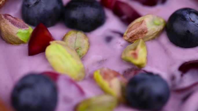 新鲜的蓝莓口味酸奶，配上成熟的樱桃和开心果