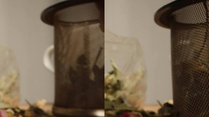 把茶叶和散落在桌子上的鲜花混合在一起，这是一种茶道。我在一个酿造筛子里放了一把。垂直视频。