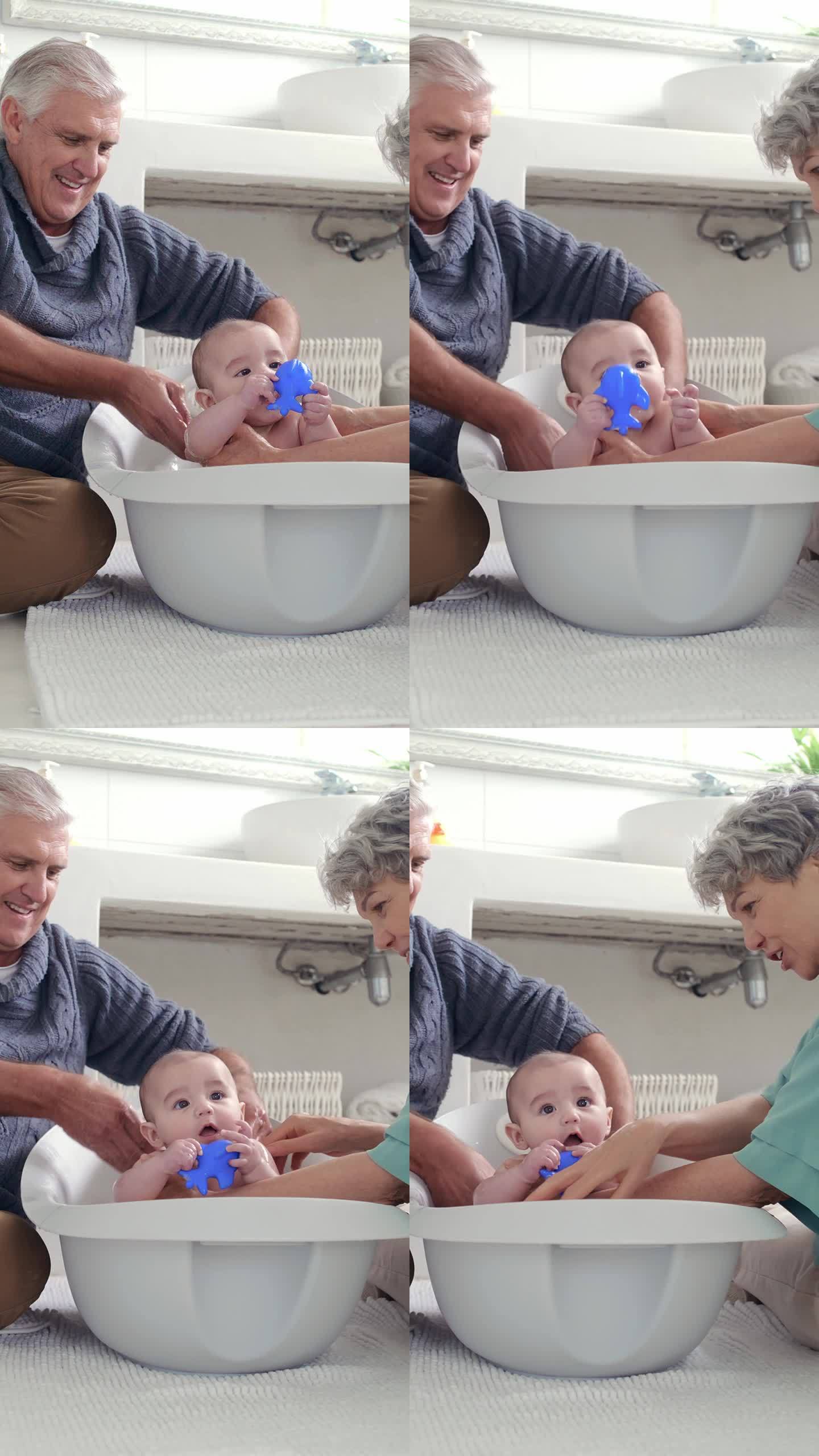 奶奶、爷爷和婴儿在浴室地板上洗澡，以保持卫生或照顾孩子。家庭，孩子和年长的祖父母或在房子里用水清洗新