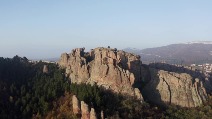 在保加利亚的维丁省，从贝洛格拉奇克岩层中拉开并缓慢撤退，露出了背景中的城镇和巴尔干山脉。