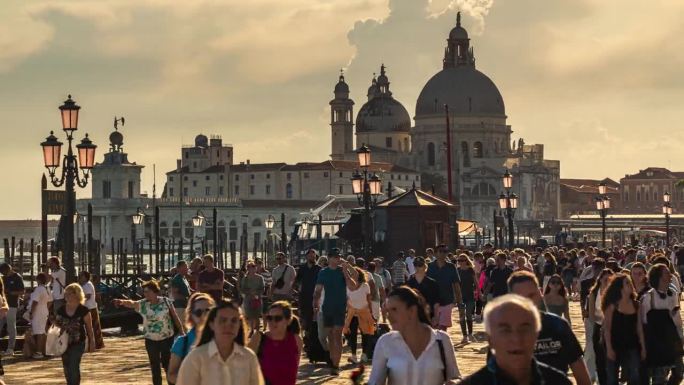 在阳光明媚的意大利威尼斯，拥挤的游客在圣玛丽亚德拉致敬广场散步和购物